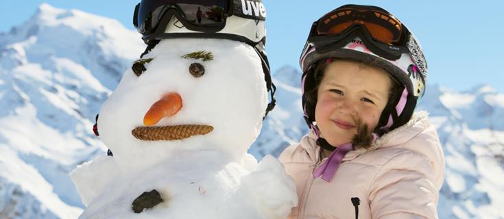 Una bambina e un pupazzo di neve